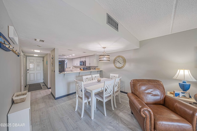 3800 S Atlantic Ave Unit 3030, Daytona Beach, FL 32118 - dining area with light wood finished floors, baseboards, and a textured ceiling