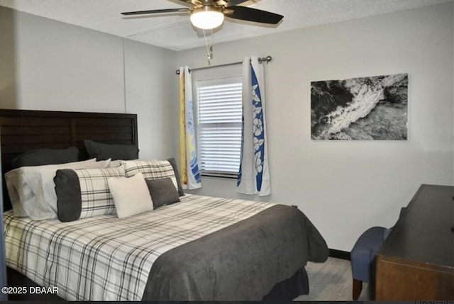 bedroom with hardwood / wood-style floors, a textured ceiling, and ceiling fan