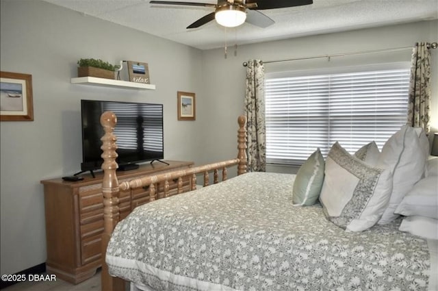 bedroom with ceiling fan and a textured ceiling