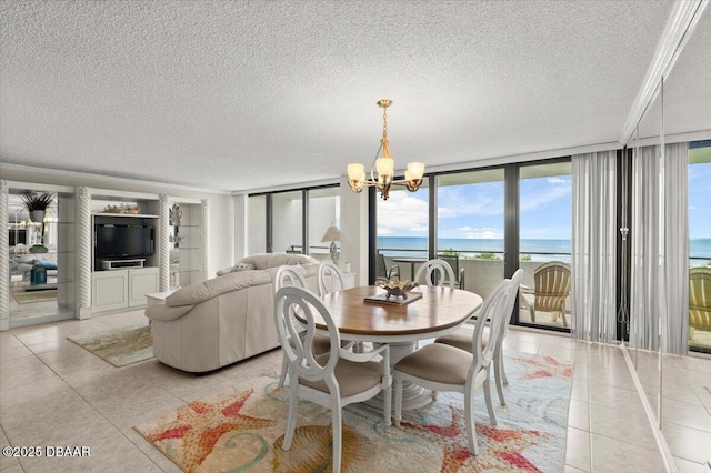 901 S Atlantic Ave Unit 202, Ormond Beach, FL 32176 - dining area featuring a textured ceiling, a chandelier, light tile patterned flooring, floor to ceiling windows, and a water view