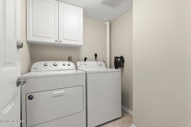 901 S Atlantic Ave Unit 202, Ormond Beach, FL 32176 - washroom with washer and dryer, cabinet space, a textured ceiling, and light tile patterned floors