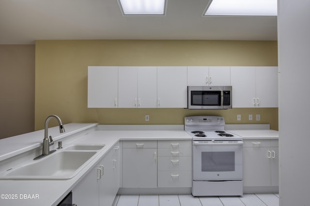 kitchen with white electric range, sink, white cabinetry, light tile patterned floors, and dishwashing machine