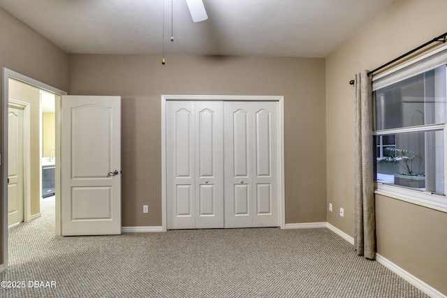 unfurnished bedroom with light colored carpet, ceiling fan, and a closet