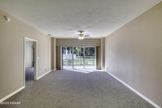 empty room featuring ceiling fan and dark colored carpet