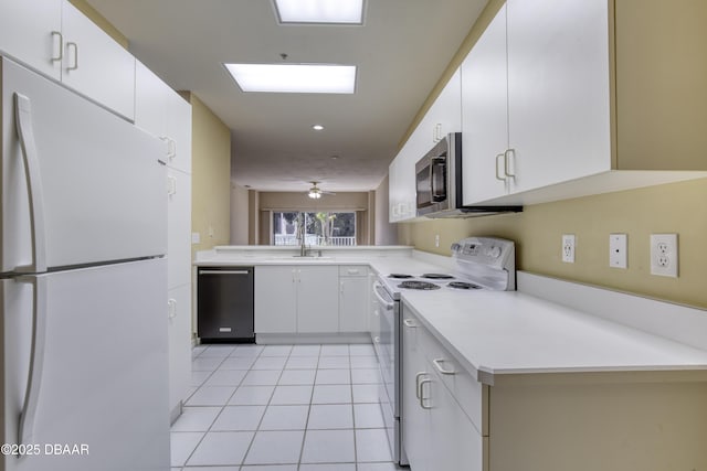 kitchen with sink, light tile patterned floors, white appliances, white cabinets, and kitchen peninsula