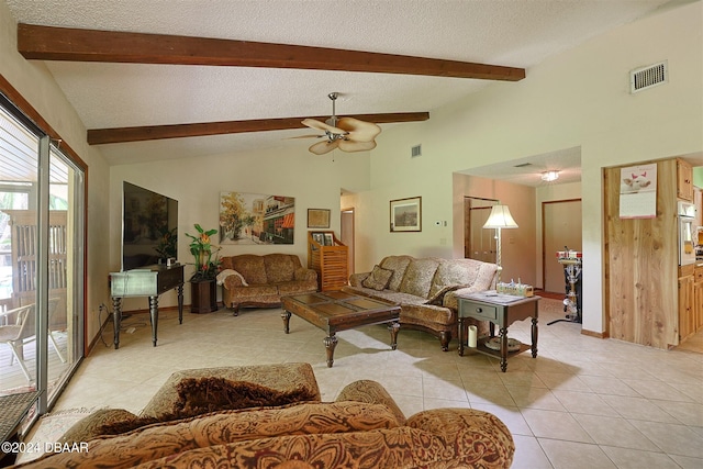 tiled living room featuring ceiling fan, beam ceiling, and a textured ceiling