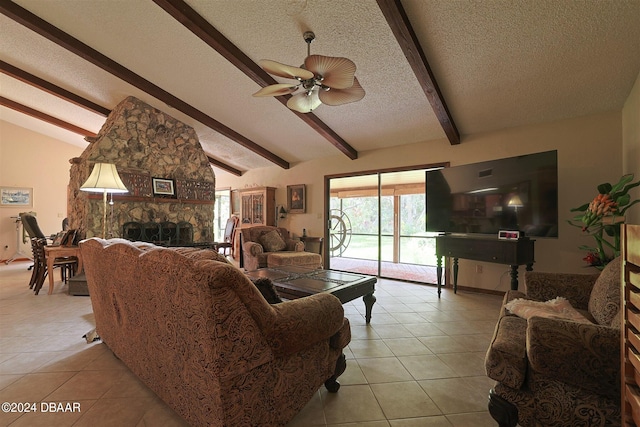 living room with light tile patterned flooring, ceiling fan, a textured ceiling, a stone fireplace, and vaulted ceiling with beams