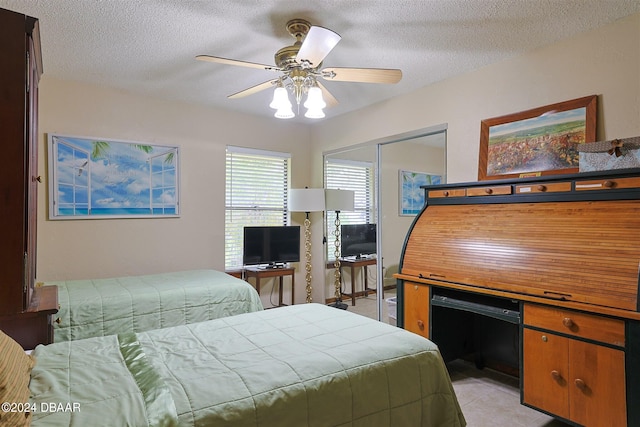 bedroom with ceiling fan, a textured ceiling, and a closet