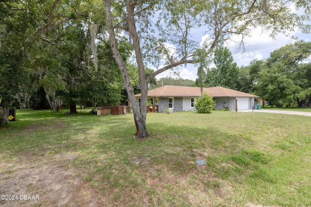 single story home with a garage and a front lawn