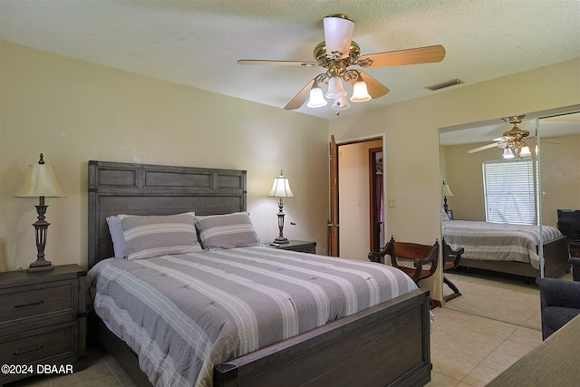 tiled bedroom featuring a textured ceiling, ceiling fan, and a closet