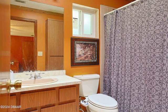 bathroom with toilet, vanity, a textured ceiling, and a shower with shower curtain