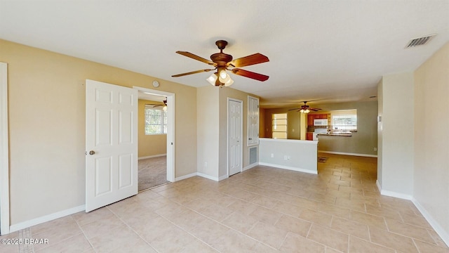 unfurnished room with light tile patterned flooring, visible vents, and baseboards