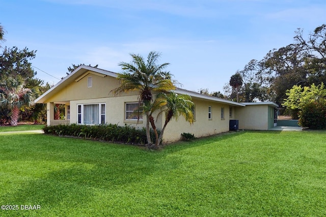 view of home's exterior with central AC unit, a lawn, and stucco siding