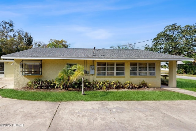 single story home featuring roof with shingles and stucco siding