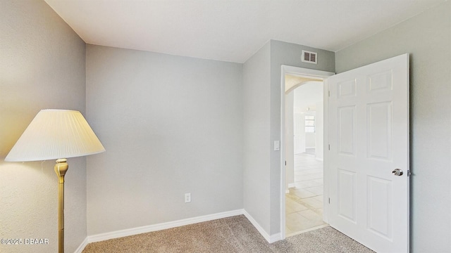 interior space with arched walkways, carpet flooring, visible vents, and baseboards