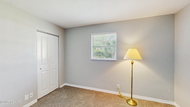 unfurnished bedroom featuring a closet, carpet flooring, and baseboards