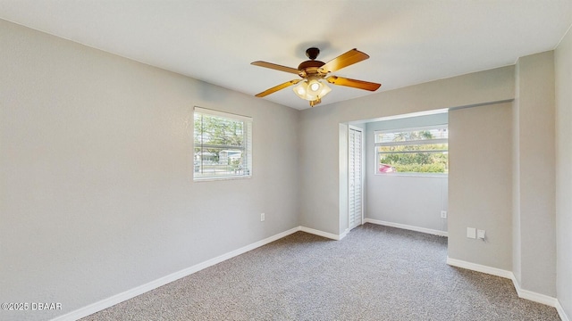 unfurnished bedroom featuring carpet floors, multiple windows, ceiling fan, and baseboards