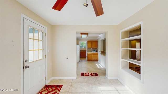 entryway with light tile patterned floors, built in features, a ceiling fan, and a healthy amount of sunlight