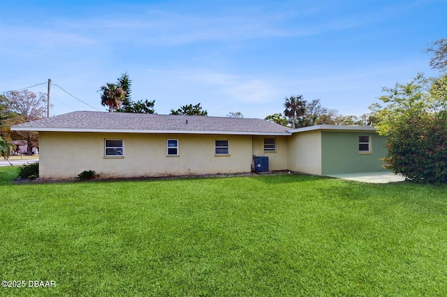 rear view of house with a patio area, stucco siding, a yard, and central air condition unit