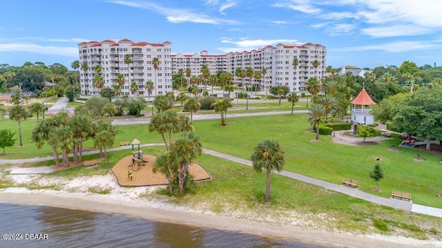 view of home's community with a beach view, a water view, and a lawn