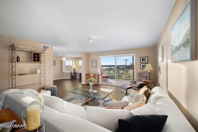 living room featuring dark wood-type flooring and ceiling fan