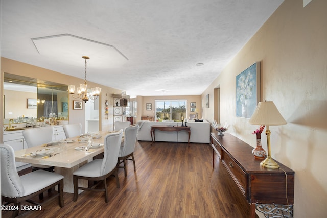 dining space featuring a textured ceiling, a notable chandelier, dark hardwood / wood-style floors, and sink