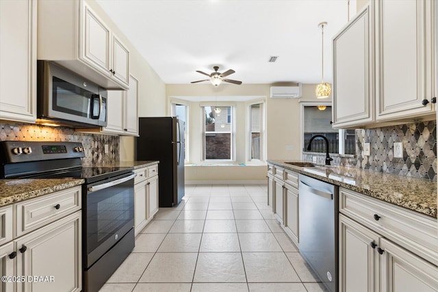 kitchen with sink, stainless steel appliances, a wall mounted air conditioner, stone countertops, and decorative light fixtures