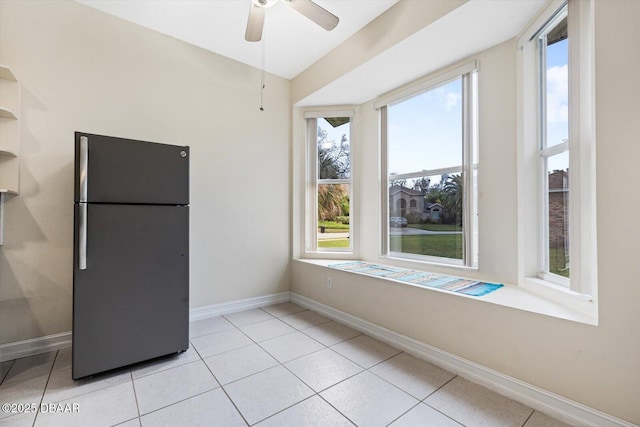 interior space featuring black refrigerator, ceiling fan, lofted ceiling, and light tile patterned floors