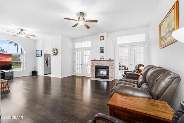 living room featuring ceiling fan, dark wood-type flooring, french doors, and a healthy amount of sunlight