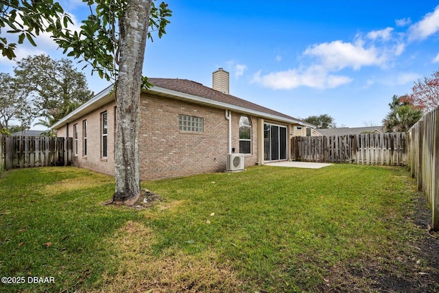 rear view of house with a yard, ac unit, and a patio