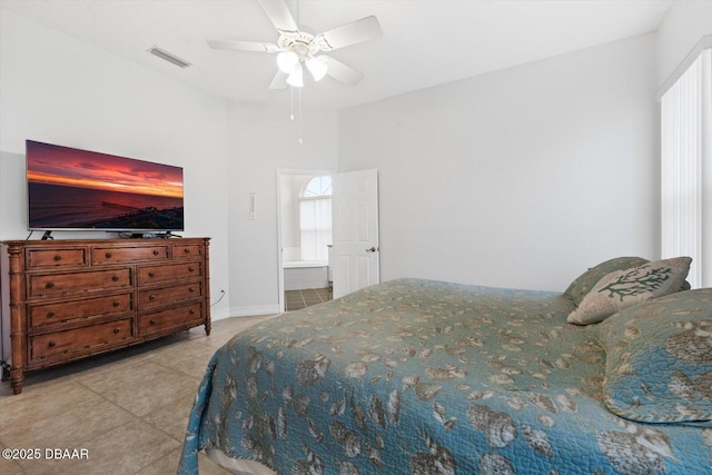 bedroom featuring connected bathroom, light tile patterned floors, and ceiling fan