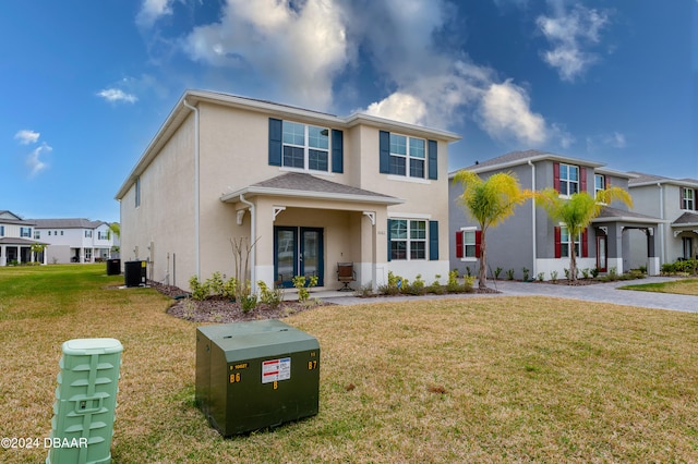 view of front of house with central AC, a front lawn, and a garage