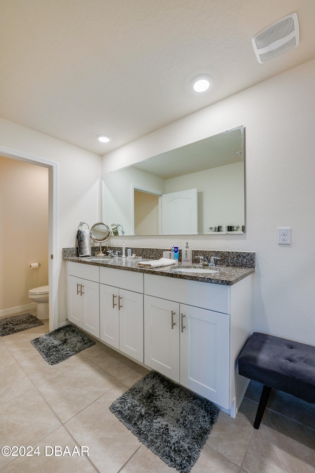 bathroom featuring toilet, vanity, and tile patterned floors