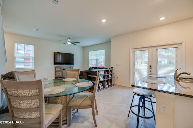 dining room featuring ceiling fan, light tile patterned floors, and sink