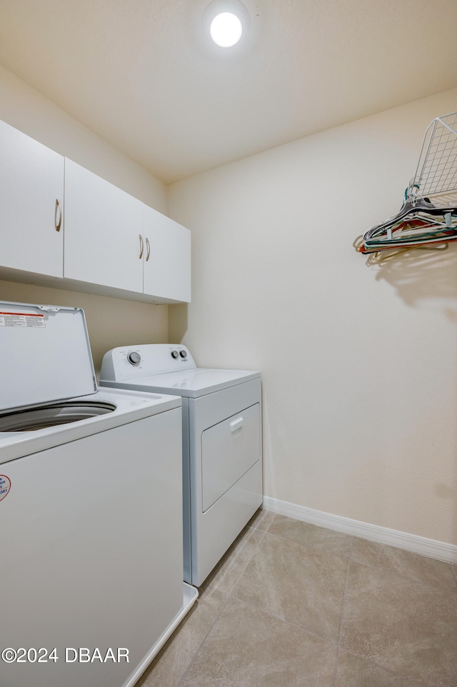 washroom with cabinets and washing machine and clothes dryer