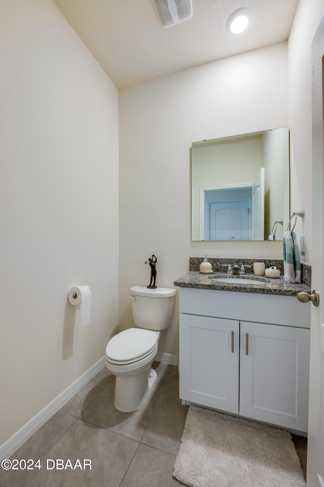 bathroom with tile patterned flooring, vanity, and toilet