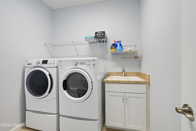 laundry room featuring washer and dryer, cabinet space, and a sink