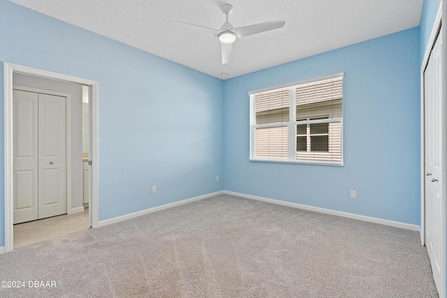 unfurnished bedroom featuring ceiling fan, a closet, baseboards, and carpet flooring