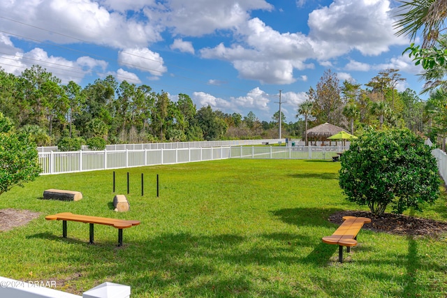 view of home's community featuring a lawn and fence