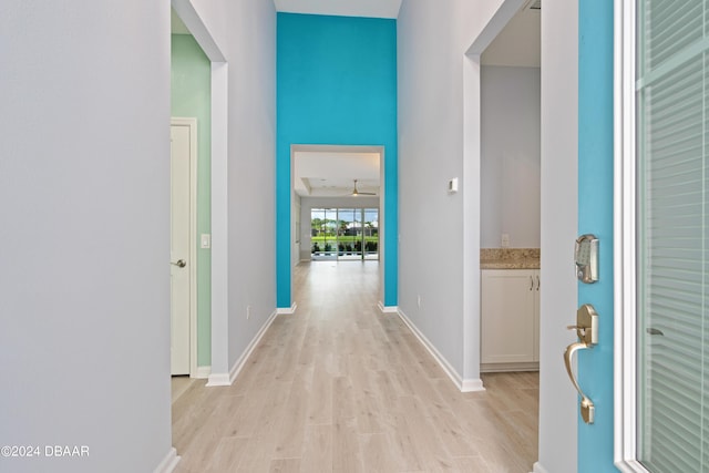 hallway featuring baseboards and light wood-style floors