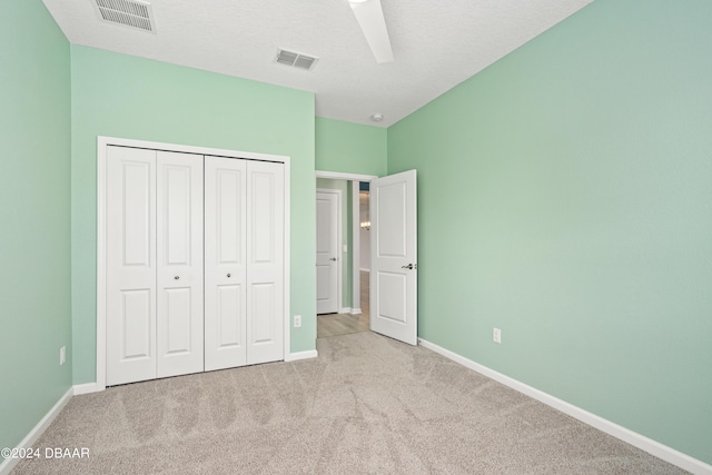 unfurnished bedroom with carpet floors, baseboards, visible vents, and a closet