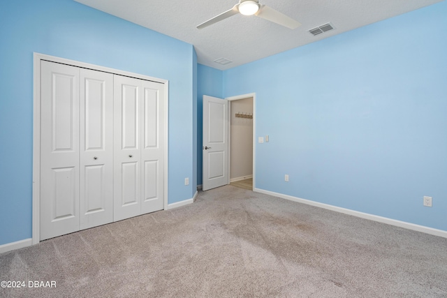 unfurnished bedroom with a closet, carpet, visible vents, and baseboards