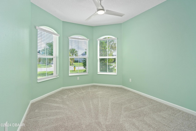 spare room with ceiling fan, carpet floors, a textured ceiling, and baseboards