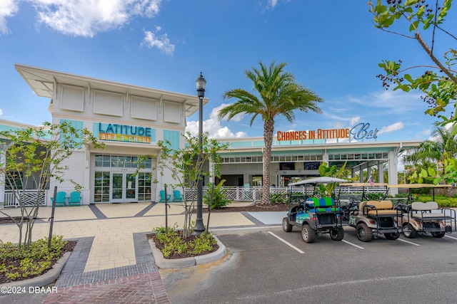 view of building exterior with uncovered parking and fence