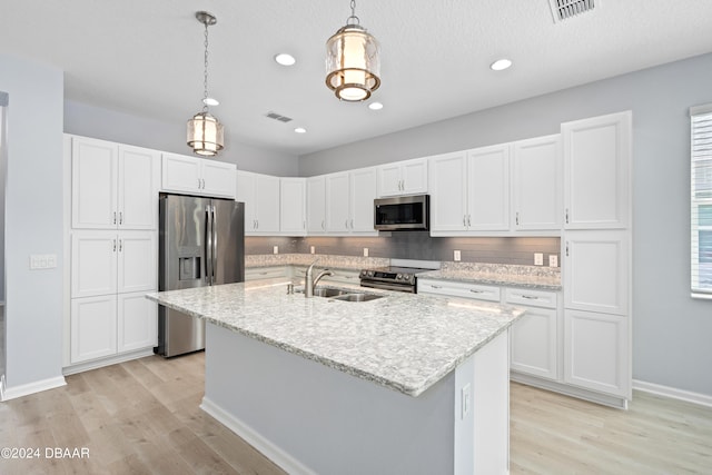 kitchen featuring stainless steel appliances, white cabinets, and visible vents