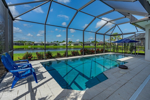 outdoor pool featuring a patio area, glass enclosure, and a water view