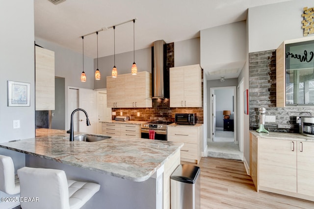 1245 Hampstead Ln, Ormond Beach, FL 32174 - kitchen with a sink, stainless steel range with electric stovetop, wall chimney range hood, a peninsula, and a breakfast bar area