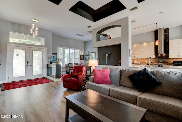1245 Hampstead Ln, Ormond Beach, FL 32174 - living area with wood finished floors, french doors, rail lighting, and a chandelier