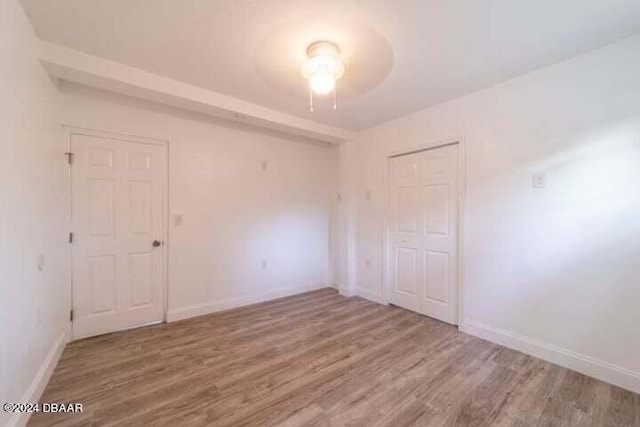 unfurnished bedroom featuring wood-type flooring and a closet