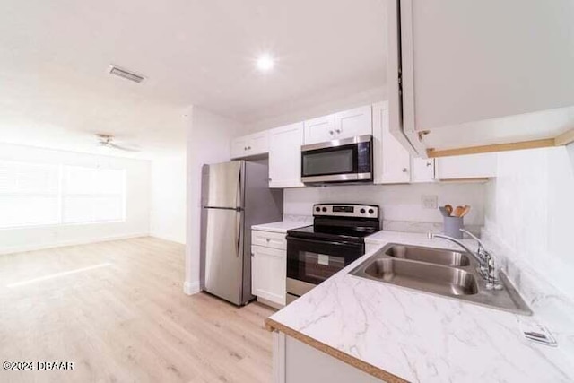 kitchen featuring white cabinetry, appliances with stainless steel finishes, sink, and light hardwood / wood-style flooring